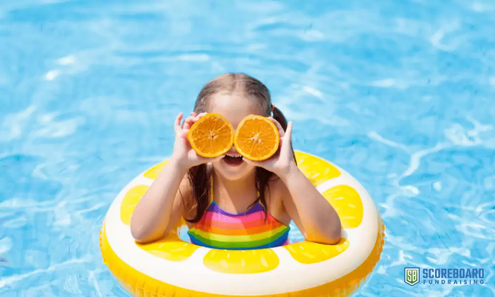 1 Girl in swimming pool with oranges.