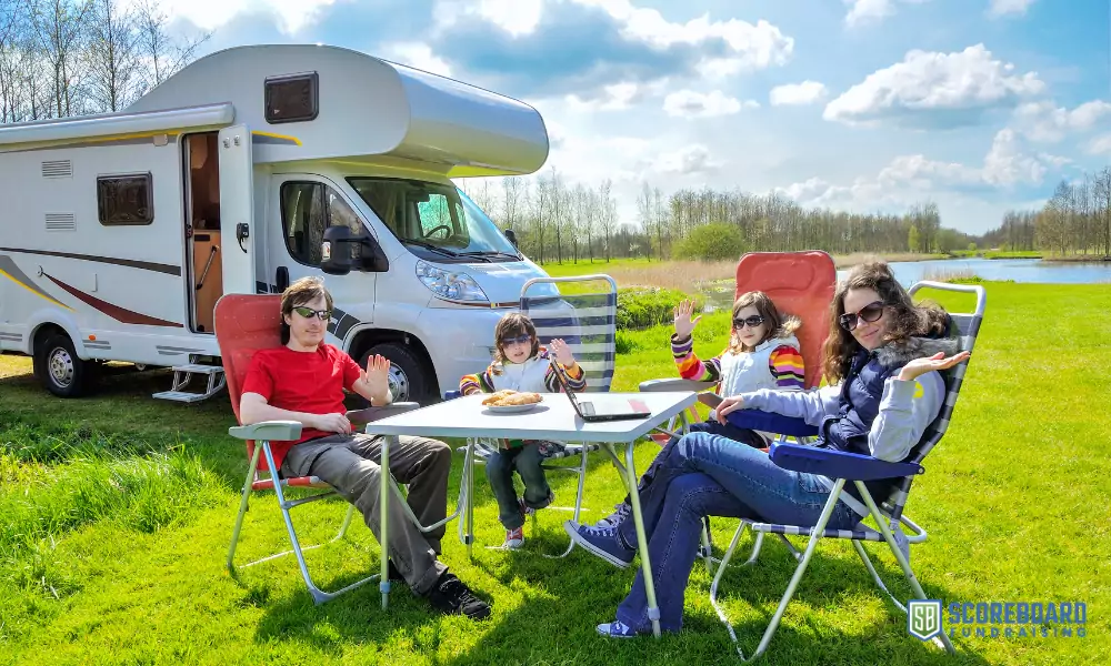 2 Family eating snacks in front of their camper.